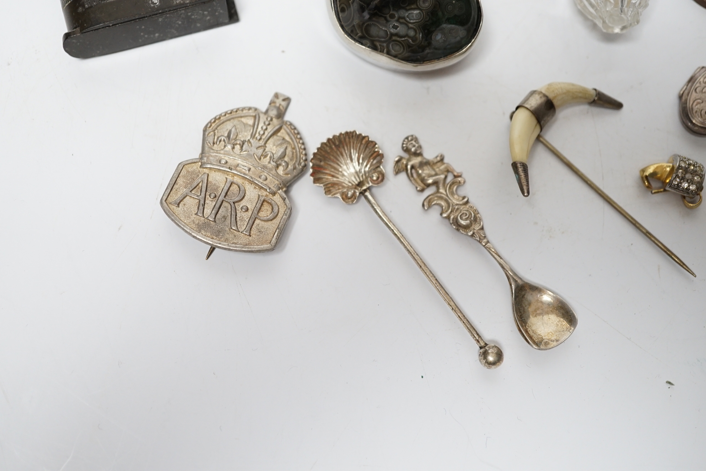 Assorted curios including phenolic vesta cases, silver condiment spoon, ARP badge, etc.